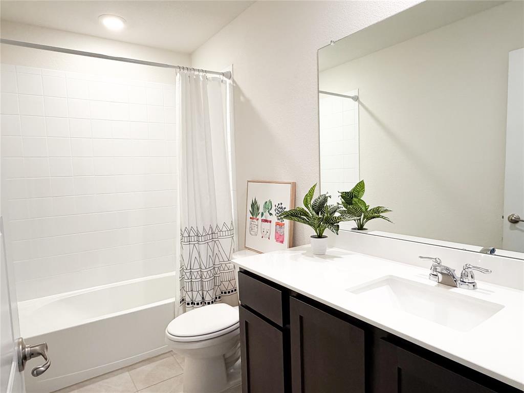 929 Philadelphia Street Fate, TX 75189 - Photo 15 of 34 a bathroom with a sink a toilet and tub