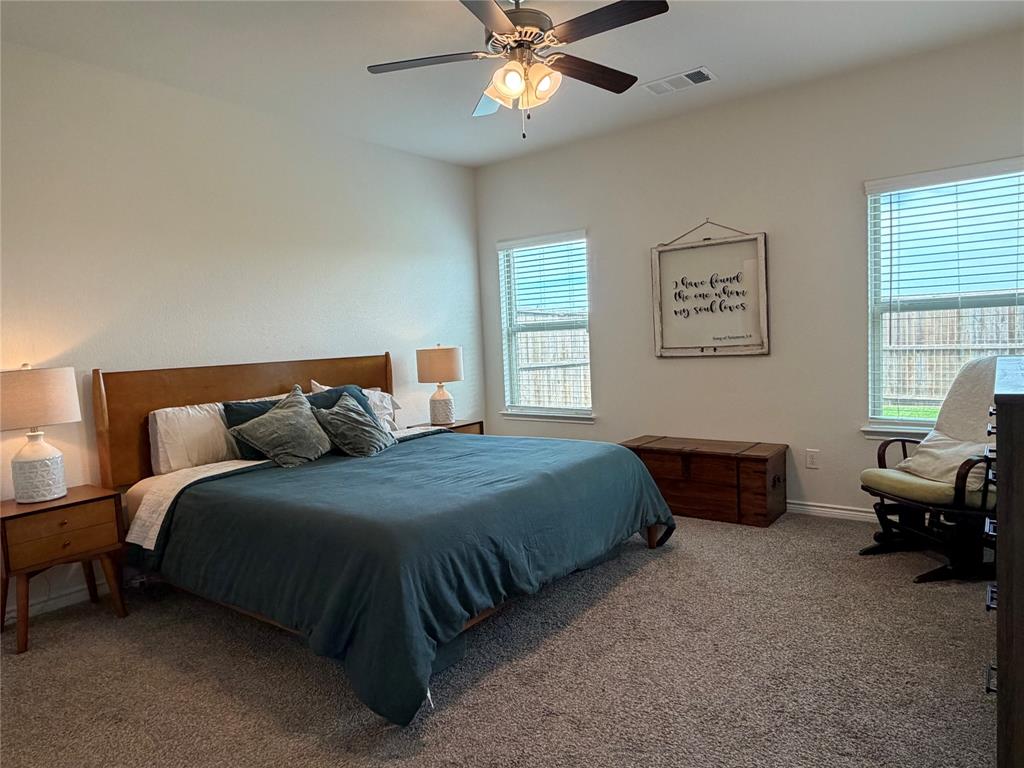 929 Philadelphia Street Fate, TX 75189 - Photo 16 of 34 a bedroom with a bed and a chandelier