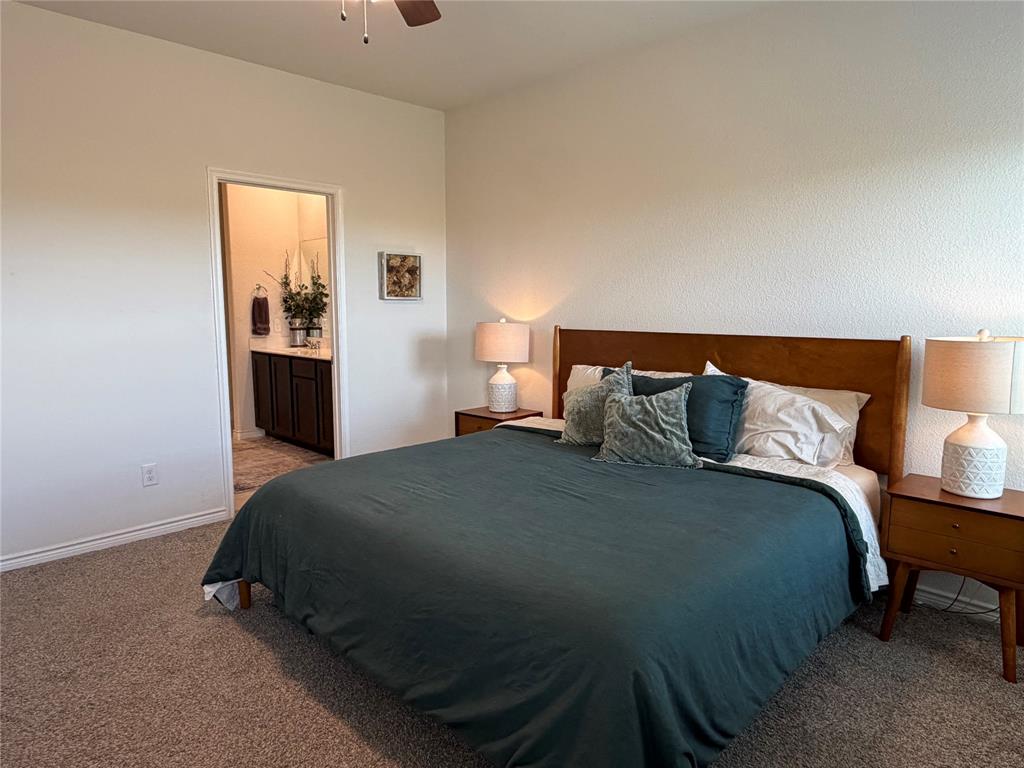 929 Philadelphia Street Fate, TX 75189 - Photo 17 of 34 a bedroom with a bed and lamp