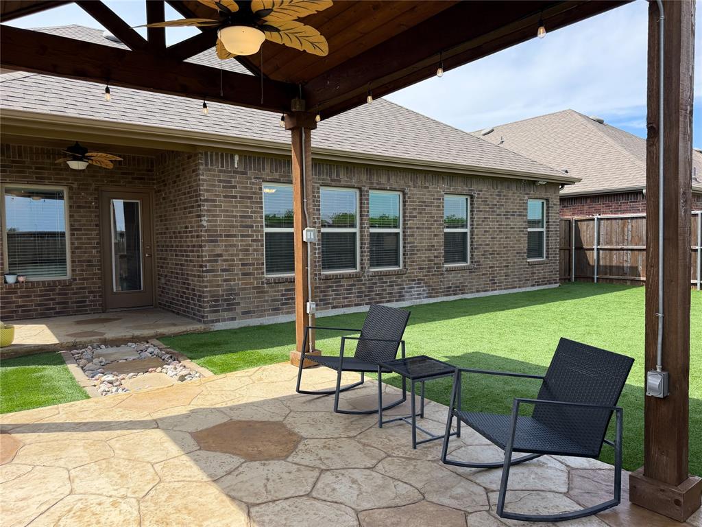 929 Philadelphia Street Fate, TX 75189 - Photo 2 of 34 a view of a backyard with table and chairs under an umbrella