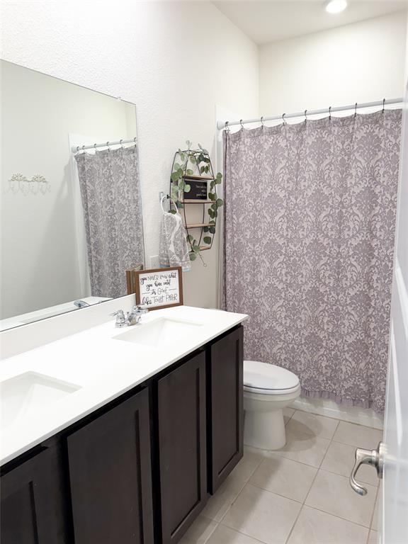 929 Philadelphia Street Fate, TX 75189 - Photo 23 of 34 a bathroom with a sink a toilet and mirror