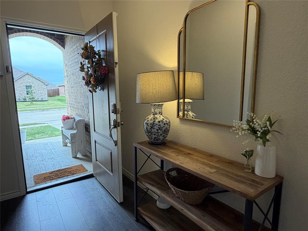 929 Philadelphia Street Fate, TX 75189 - Photo 5 of 34 a view of a hallway with paintings on the wall and wooden floor