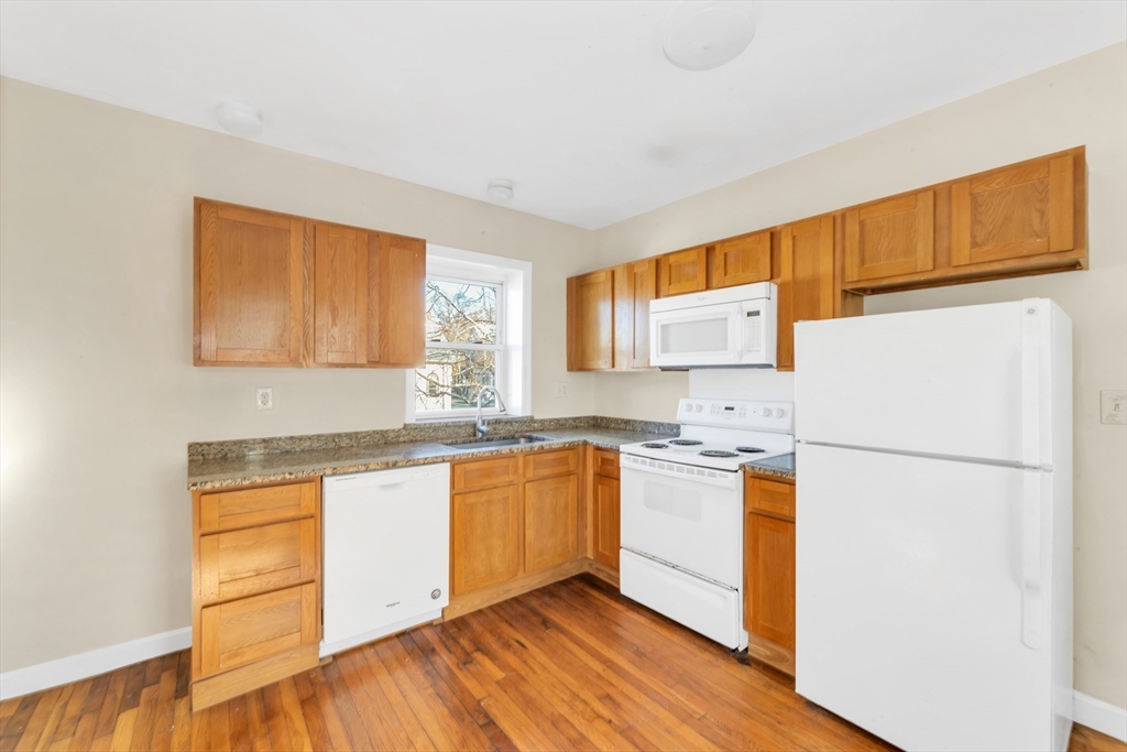 53 Brookside Avenue Boston, MA 02130 - Photo 12 of 28 a kitchen with stainless steel appliances granite countertop a refrigerator a stove a sink and a microwave