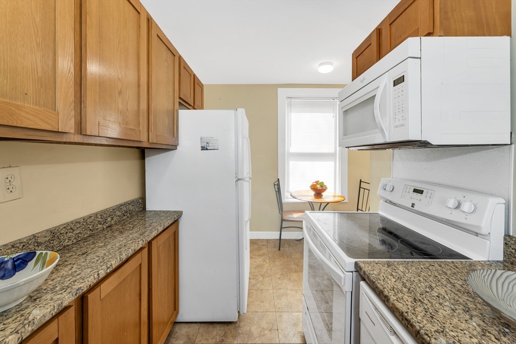 53 Brookside Avenue Boston, MA 02130 - Photo 9 of 28 a kitchen with granite countertop a sink a stove and refrigerator