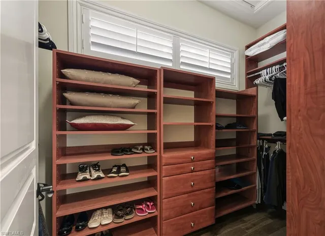 a view of walk in closet with clothes and shoes