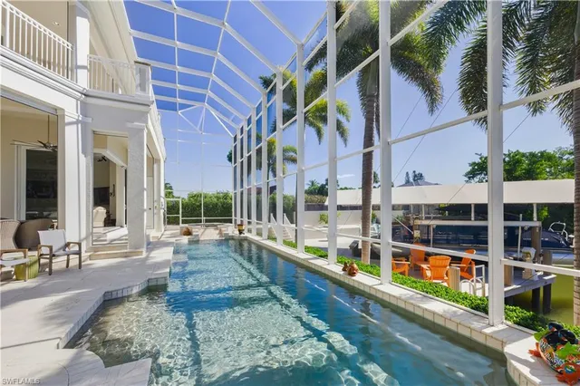 a living room with furniture a large window and stainless steel appliances