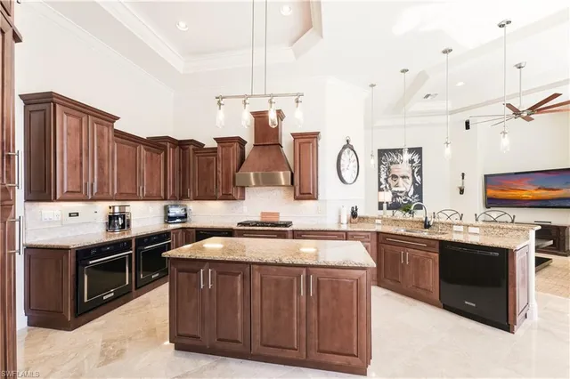 a kitchen with stainless steel appliances granite countertop a sink a stove and a wooden cabinets