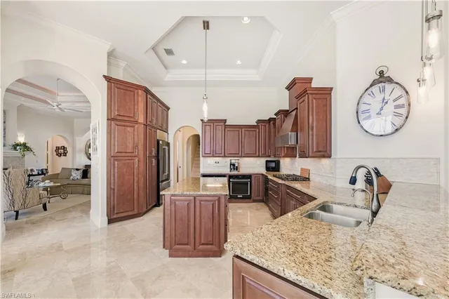 a kitchen with stainless steel appliances granite countertop a sink a stove and a refrigerator with wooden floor