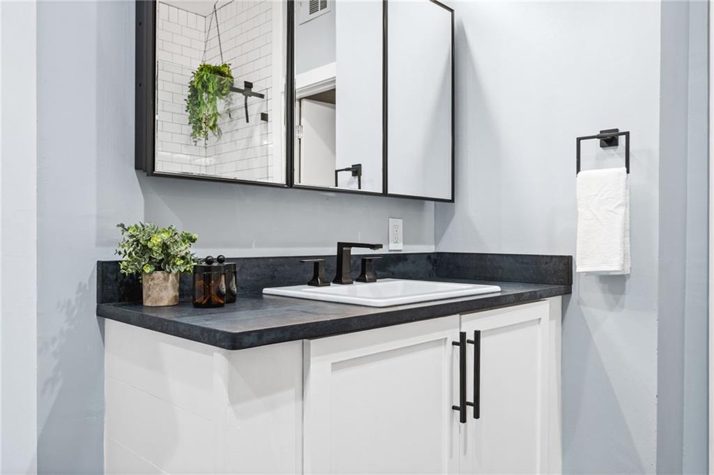 1029 Piedmont Avenue Northeast, Unit 303 Atlanta, GA 30309 - Photo 20 of 44 a kitchen with stainless steel appliances granite countertop a sink and a white cabinets with wooden floor