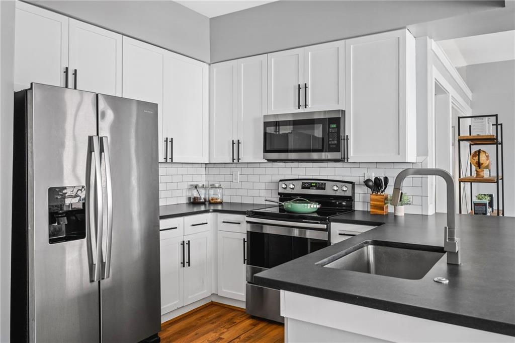 1029 Piedmont Avenue Northeast, Unit 303 Atlanta, GA 30309 - Photo 9 of 44 a kitchen with refrigerator a microwave a sink and cabinets