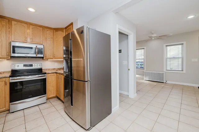 a kitchen with granite countertop a refrigerator and a stove top oven