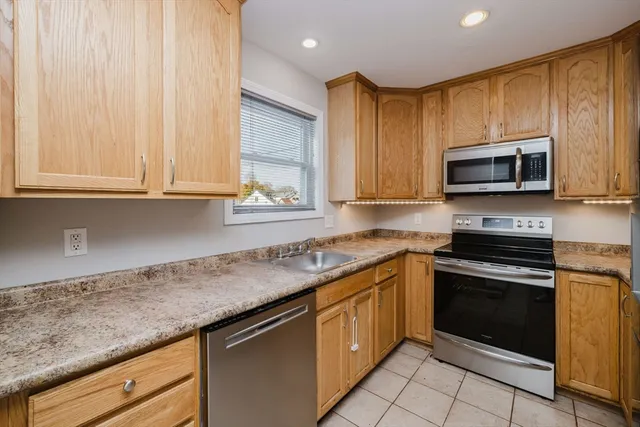 a kitchen with granite countertop a stove top oven microwave and cabinets