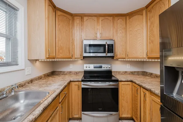 a kitchen with granite countertop a sink a stove a microwave and cabinets