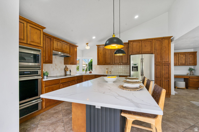 432 Calnette Drive Sandy, UT 84070 - Photo 3 of 48 Vaulted ceiling kitchen featuring a large island with a quartz countertop, recessed and pendant lighting, stainless steel appliances, and wood cabinetry