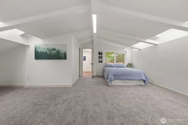 a spacious bedroom with a bed and a flat screen tv