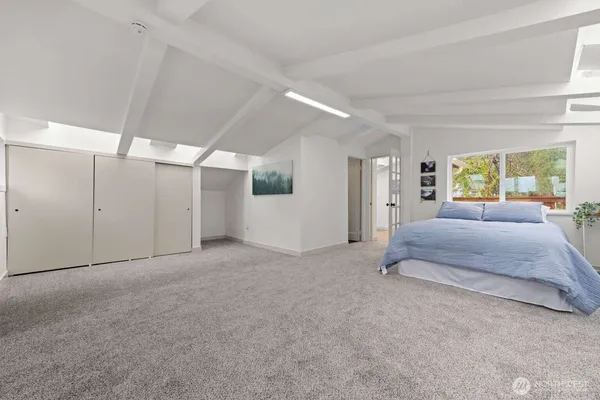 a spacious bedroom with a large bed and a large window