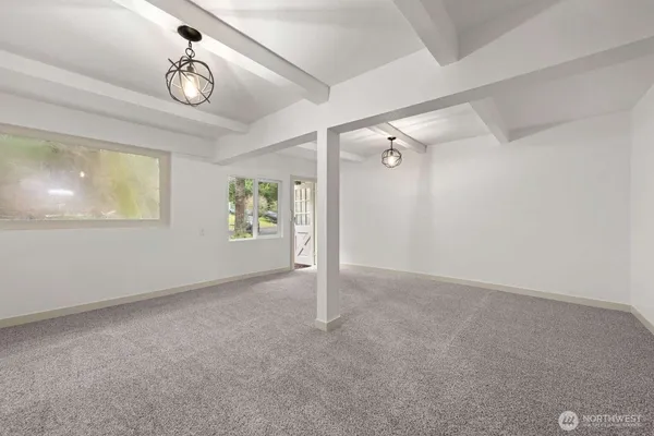en empty room with windows and ceiling fan