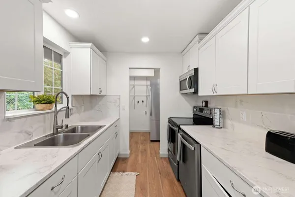 a kitchen with a sink a stove and cabinets