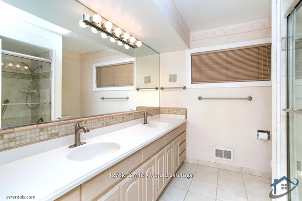a bathroom with a double vanity sink a mirror and a shower