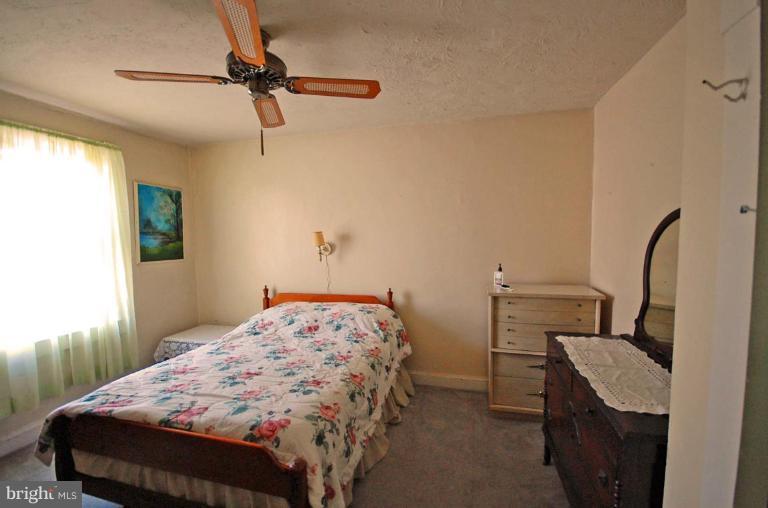 2261 Sidney Avenue Baltimore, MD 21230 - Photo 4 of 11 a bedroom with a bed and a dresser