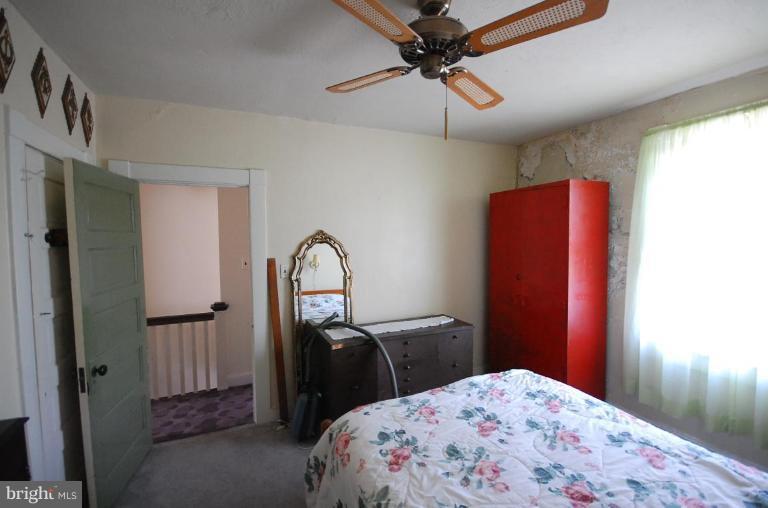 2261 Sidney Avenue Baltimore, MD 21230 - Photo 9 of 11 a bedroom with a bed and a chandelier