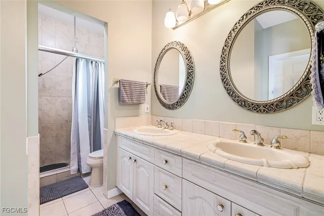 a bathroom with a granite countertop double vanity sink and a mirror