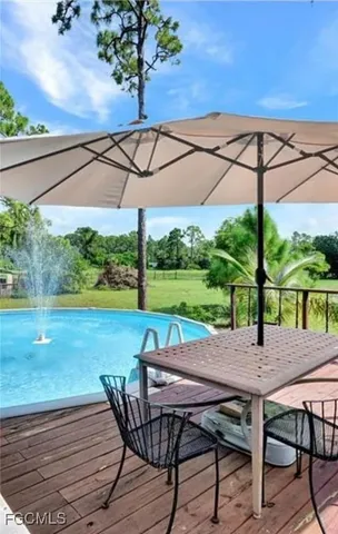 a view of a patio with table and chairs under an umbrella