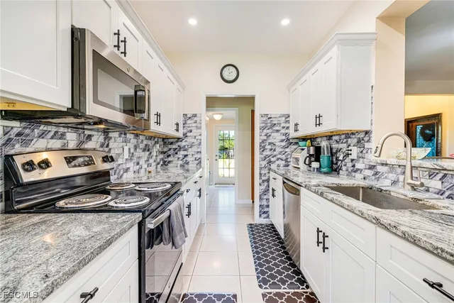 a kitchen with stainless steel appliances granite countertop a stove and a sink