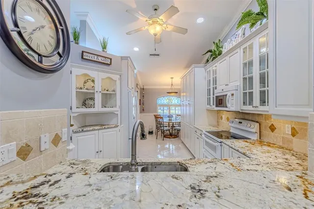 a view of a kitchen with granite countertop living room and stainless steel appliances