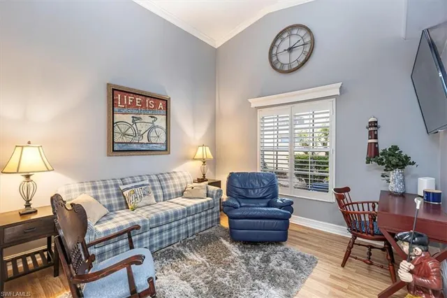 a living room with furniture a clock on wall and a window