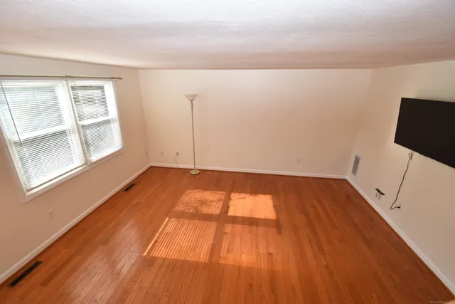 a view of a room with wooden floor and flat screen tv