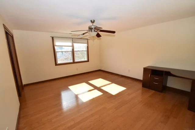 an empty room with windows and fan