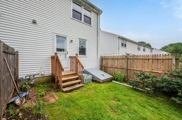 a view of a house with backyard and wooden fence