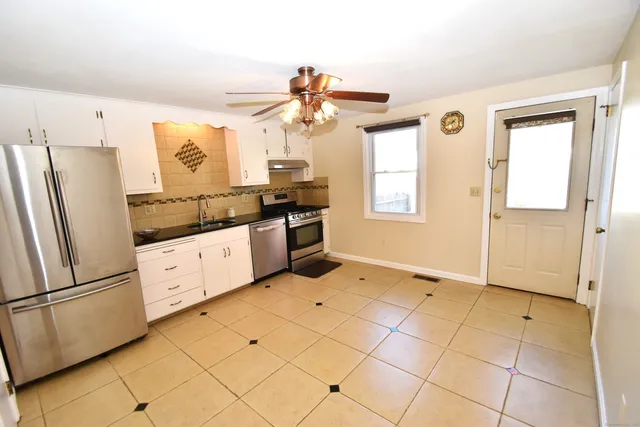a kitchen with stainless steel appliances a refrigerator sink and cabinets