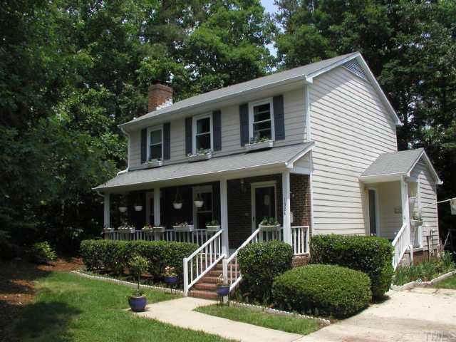 1304 Suterland Road Cary, NC 27511 - Photo 1 of 1 a view of a white house next to a yard with plants and trees