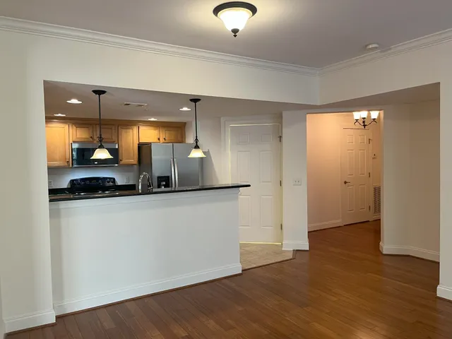 a kitchen with a sink a counter top space cabinets and stainless steel appliances