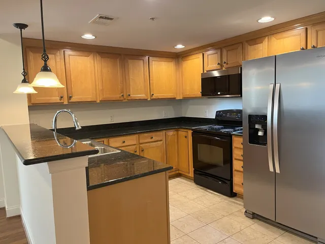 a kitchen with stainless steel appliances granite countertop a stove a refrigerator and a microwave