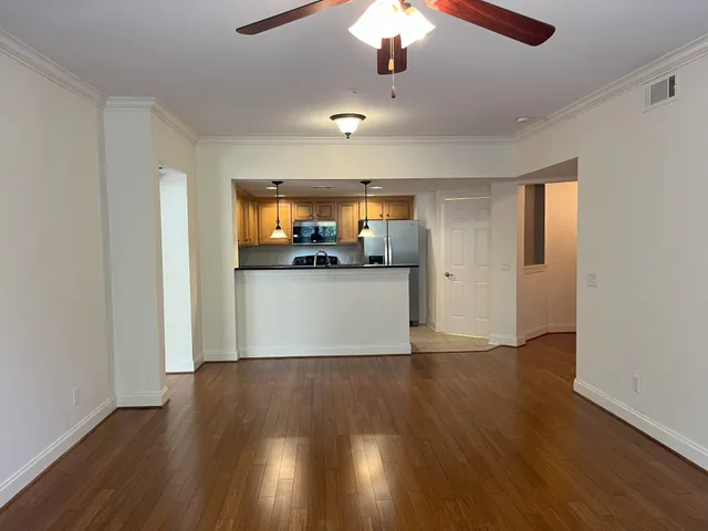 a view of a kitchen with a dishwasher a kitchen wooden floor and a ceiling fan