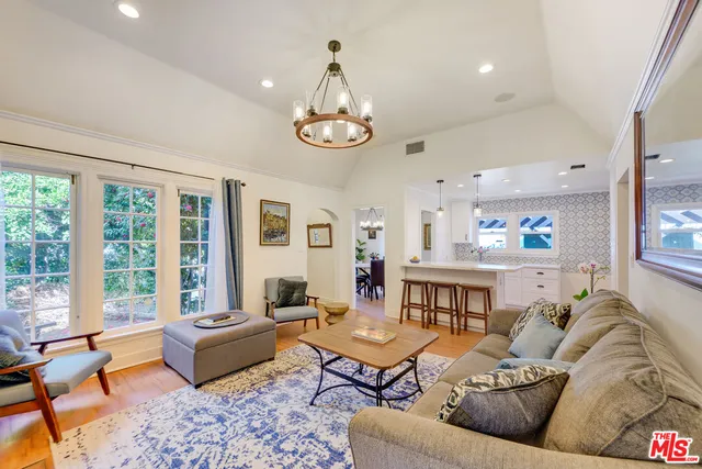 a living room with furniture kitchen view and a large window