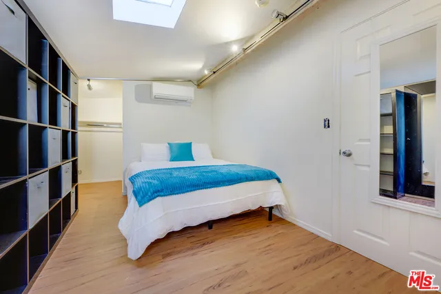 a bedroom with a bed and a book shelf