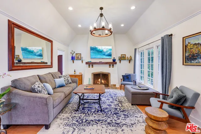a living room with furniture a fireplace and a large window