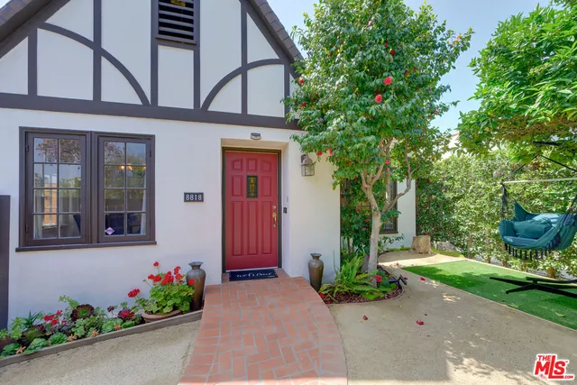 a front view of a house with a yard and potted plants
