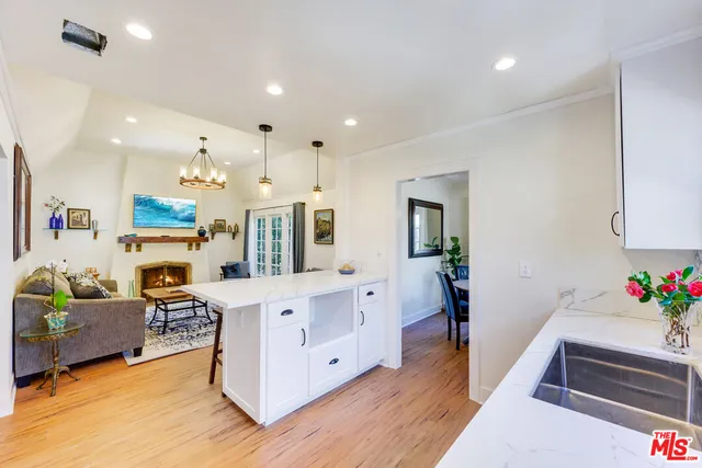 a large white kitchen with lots of counter space furniture and a wooden floor
