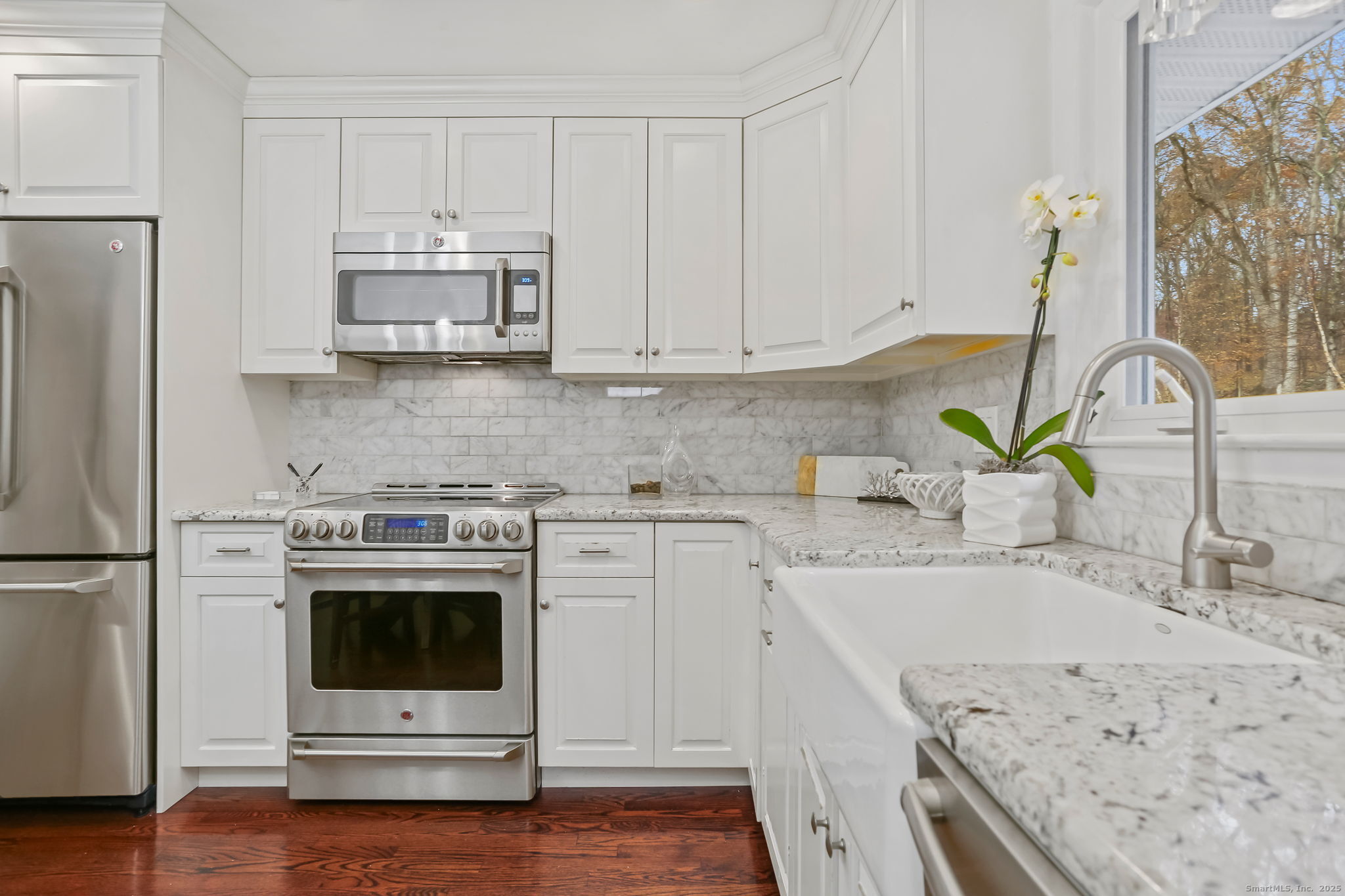 24 Warnock Drive Westport, CT 06880 - Photo 12 of 31 a kitchen with stainless steel appliances granite countertop a sink stove and white cabinets