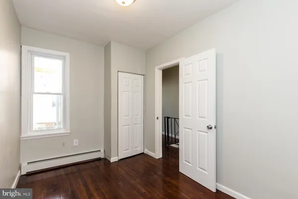 an empty room with wooden floor and a window