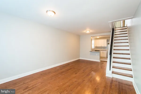 a view of a kitchen with wooden floor and staircase