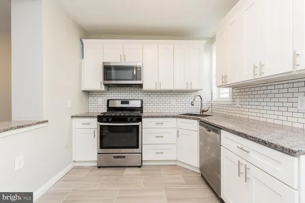a kitchen with cabinets stainless steel appliances and a window