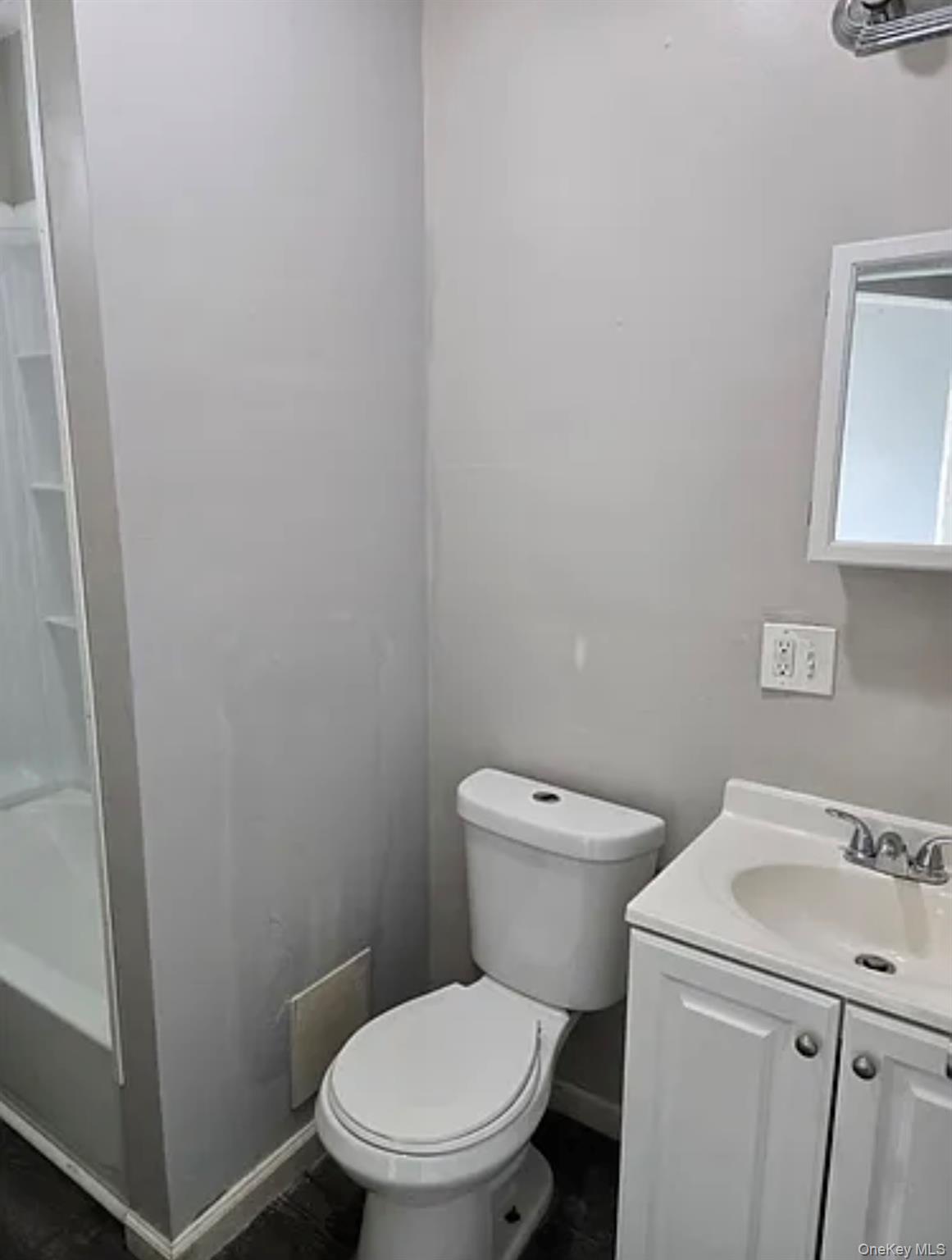 146 Mansion Street, Unit 2 Poughkeepsie, NY 12601 - Photo 12 of 14 a white toilet sitting next to a white sink and vanity