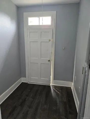 an empty room with wooden floor and window