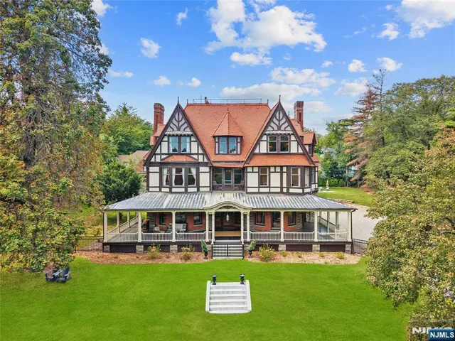 a view of a house with a big yard and large trees